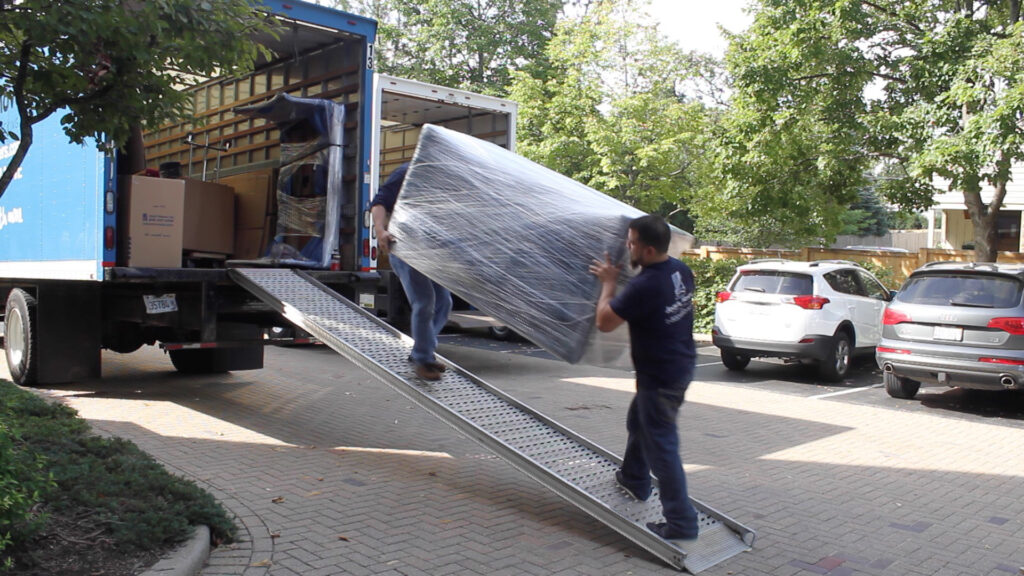 Refrigerator movers using protective blankets and equipment.